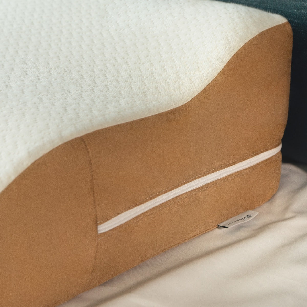 Brown and white wedge pillow on a bed