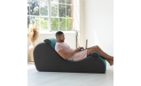 Man working on laptop on Chakra Yoga Chaise